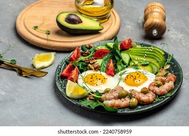 shrimps, prawns, soft fried egg, fresh salad, tomatoes, cucumbers and avocado on a light background. Ketogenic diet breakfast. Keto, paleo lunch. Top view.