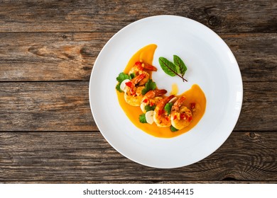 Shrimps salad with ginger and chili in mango sauce on wooden table 