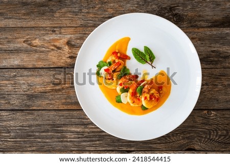 Shrimps salad with ginger and chili in mango sauce on wooden table 