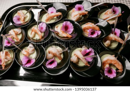 Shrimps with spicy sauce. the sauce is decorated with flower petals