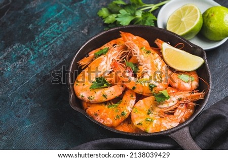 Shrimps stir-fried or roasted tasty argentine jumbo shrimps in pan copy space dark background.