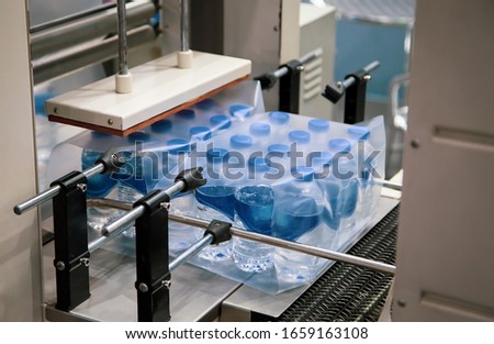 Shrink film wrapping machine for bottle of water. Food industry