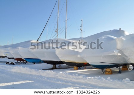 Shrinkwrap row of boats in the snow