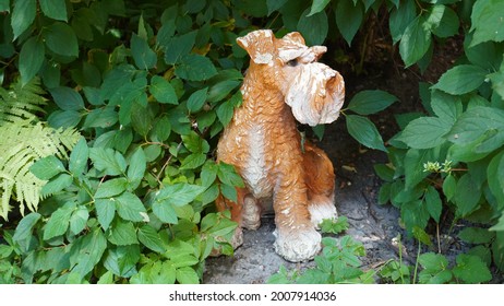 shrub of a garden plot with a decor in the form of a dog figure in summer