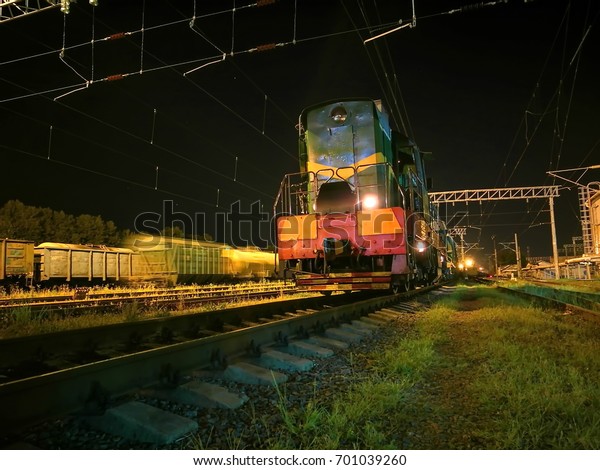 Shunting\
diesel locomotive in the rail yard by\
night.