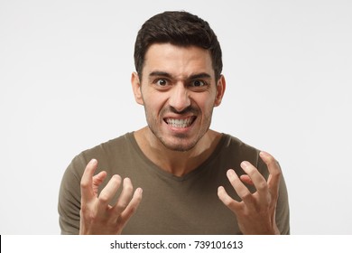 Shut Up Concept. Mad Young Man Bite His Teeth, Gesturing With Hands. Studio Portrait Of Angry And Irritated Male Yelling, Looking Crazy And Full Of Anger