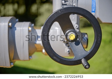 Shut-off device of the gas pipeline in emergency areas. Close up of oil and gas pipelines and valves on green grass background