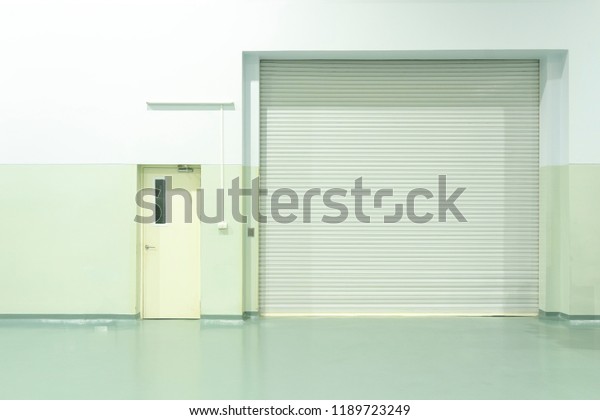 Shutter door or roller door and concrete floor inside\
factory building 
