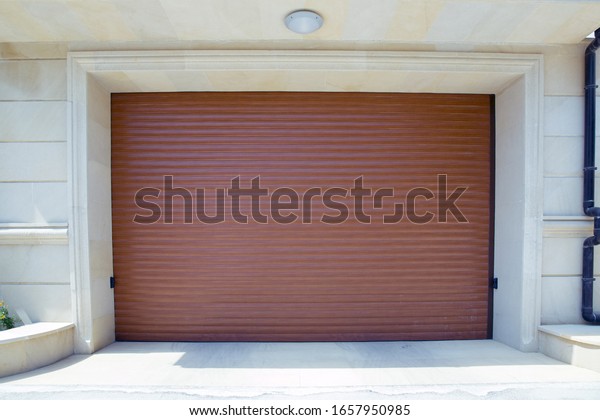 Shutter door or roller door and concrete floor\
outside .White Automatic shutters in a house . gates in the garage\
. Automatic Electric Roll-up Gate Or Push-up Door In The Modern\
Building Ground Floor