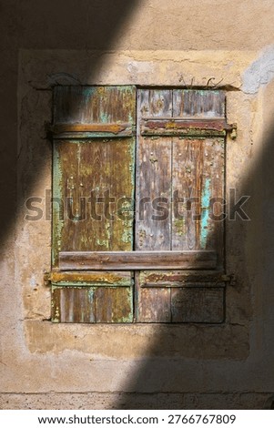 A shutter with peeling paint on an old, dilapidated, vacant house in the historic old town of Meissen, Germany