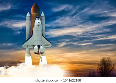 A Shuttle Spaceship Launch On Background Of Blue Night Cloudy Sky.