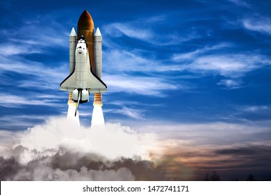 A shuttle spaceship taking off on background of blue night cloudy sky. - Powered by Shutterstock