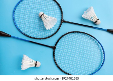 Shuttlecocks and badminton rackets on blue background. Top view