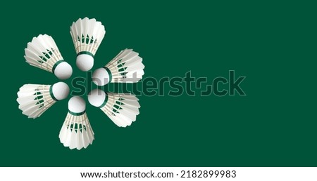 Shuttlecocks on green background, flat lay. Space for text