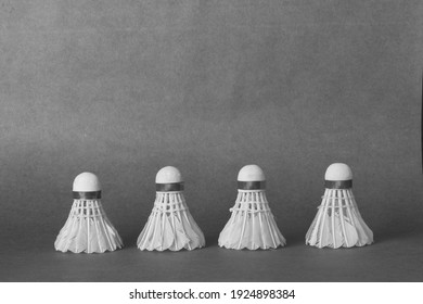 Shuttlecocks placed in a row on textured background. Black and white image.