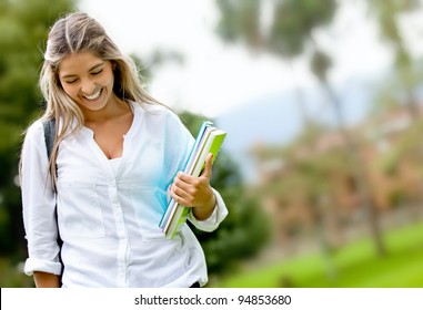 Shy Female Student Walking Outdoors And Smiling