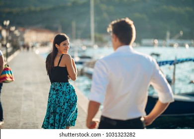 Shy flirty woman smiling to a man.Man giving a compliment to a introvert passing woman.Receiving a compliment on the street.Public complimenting.Flattering comment,feminine walking.Catcalling