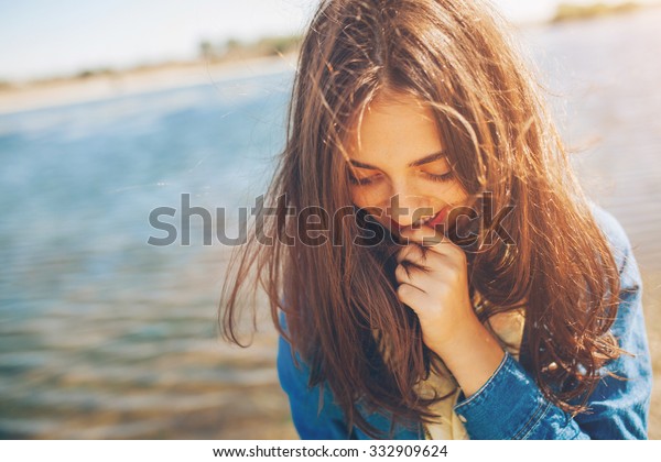 下を見下ろすシャイな女の子 湖の背景にかわいい10代の女の子がシャイ フィルムエフェクト の写真素材 今すぐ編集
