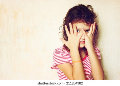 Shy Kid Peeking Through Covered Face. Filtered Image.