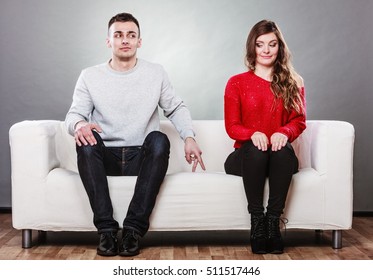 Shy Woman And Man. Guy Sitting Near Attractive Young Woman On Sofa And Making Hand Gesture Walking With Finger To Girl