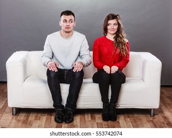 Shy Woman And Man Sitting On Sofa Couch Next Each Other. First Date. Pretty Girl And Handsome Guy Meeting Dating And Trying To Talk.