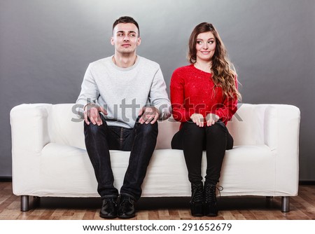 Shy woman and man sitting on sofa couch next each other. First date. Attractive girl and handsome guy meeting dating and trying to talk. Foto d'archivio © 