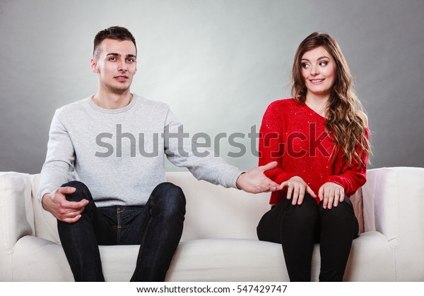 シャイな女性と男性が隣り合わせのソファに座っている 最初の日付 魅力的な女の子とハンサムな男が出会い話し合う 女性に手を差し出す男性 の写真素材 今すぐ編集