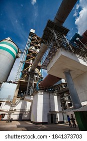 Shymkent/Kazakhstan - April 27 2012: Standard Cement Plant. Rotary Clinker Kiln, Concrete Silo Tower And Tubes . Blue Sky Background.