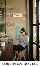 Siantar, Indonesia - December 19, 2019 : A Woman Is Enjoying Coffee In A Quiet Room.