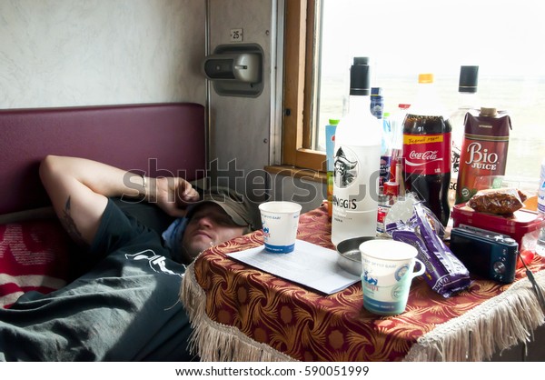 SIBERIA,\
RUSSIA - May 14, 2012: Tired passenger in a cabin on-board the\
trans-Siberian train from Beijing to\
Moscow