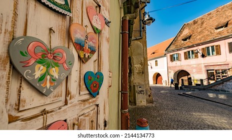 SIBIU, ROMANIA - March 2022: Old town of Sibiu. Traditional colorful heart shaped souvenirs in Sibiu historical town, Romania