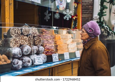 Sibiu, Romania; Nov 21 2018: Old Lady Buying Sweets In Christmas Market In Eastern European City