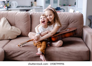 Sibling Brother And Sister Play Together. Child With Cerebral Palsy With Family In Rehabilitation. Inclusion Friendship With A Disabled Person. Music Therapy Playing The Guitar. Sensory Emotions Fun