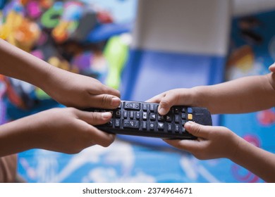 sibling fight over tv remote in a messy living room - Powered by Shutterstock