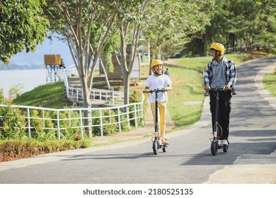 Sibling on vacation having fun to ride electric scooter through the street park. Youth Leisure Family Concept. - Powered by Shutterstock