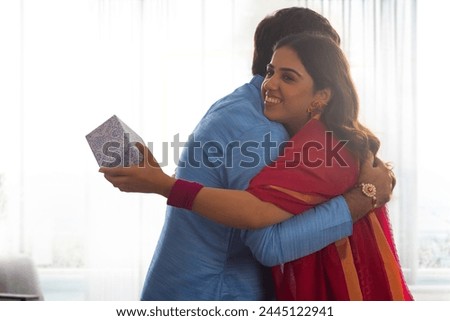 Sibling sharing gift and embracing on Raksha Bandhan