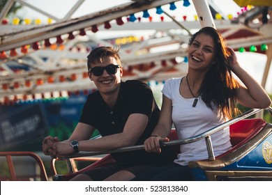 Siblings at an amusement park. Having a ride on a ferris wheel. Enjoying holidays together. Bonding concept.Friendship between opposite sexes.Best friends having fun in the summer time.