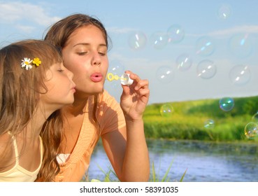 Siblings blowing soap bubbles