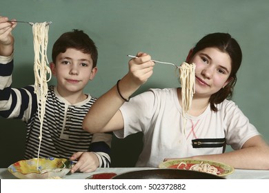siblings boy and girl with spaghetti close up photo