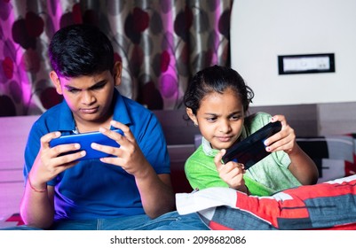 Siblings Busy Playing Video Game On Mobile Phone During Night Sleep - Concept Of Kids Gaming Addiction, Childhood Lifestyles And Technology.