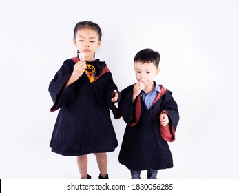 Siblings Dressed up in Robes For Halloween on White background