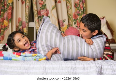 Siblings Enjoying a Pillow Fight