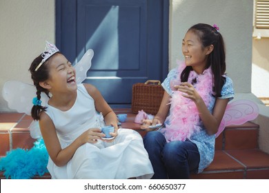 Siblings in fairy costume having a tea party at home - Powered by Shutterstock