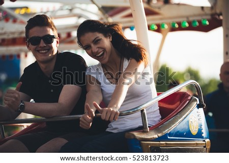 Siblings having fun at an amusement park. Having a ride on a ferris wheel. Spending holidays together. Bonding concept.Man and woman friendship.Enjoying summer holiday.