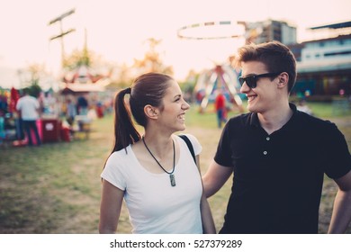 Siblings having a great time at an amusement park. Smiling and enjoying in sunny summer day. Siblings bonding. Spending quality time.