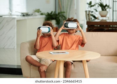 Siblings in headsets playing virtual reality game at home - Powered by Shutterstock