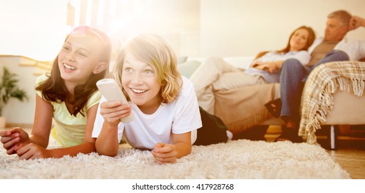 Siblings lying on the floor watching tv together