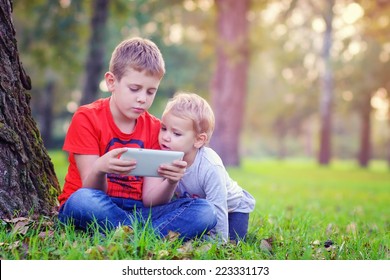 Siblings using a tablet  - Shutterstock ID 223331173