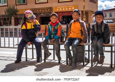 Sichuan, China - October 14, 2016 : Tibetan kids sitting in the chairs on the street. - Shutterstock ID 793972267