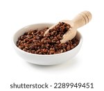 Sichuan pepper in a white bowl set against a white background. Sichuan pepper is a member of the sansho family used in Chinese cooking. Viewed from directly above.